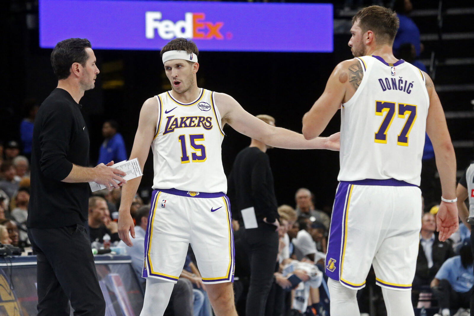 Oct 31, 2025; Memphis, Tennessee, USA; Los Angeles Lakers head coach JJ Redick talks with guard Austin Reaves (15) and guard Luka Doncic (77) during the fourth quarter against the Memphis Grizzlies at FedExForum. Mandatory Credit: Petre Thomas-Imagn Images