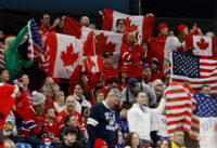 Feb 22, 2026; Milan, Italy; Canada and United States fans wave flags in the men's ice hockey gold medal game during the Milano Cortina 2026 Olympic Winter Games at Milano Santagiulia Ice Hockey Arena. Mandatory Credit: Geoff Burke-Imagn Images
