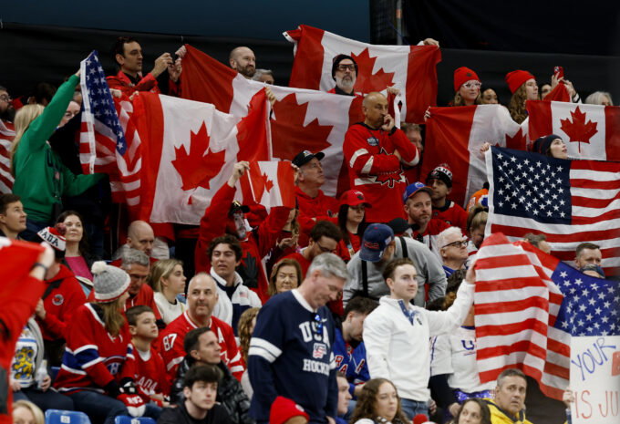 Feb 22, 2026; Milan, Italy; Canada and United States fans wave flags in the men's ice hockey gold medal game during the Milano Cortina 2026 Olympic Winter Games at Milano Santagiulia Ice Hockey Arena. Mandatory Credit: Geoff Burke-Imagn Images