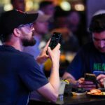 May 9, 2024; Columbus, OH, USA; Alex Bucci, left, of Worthington and Richard Mettke of German Village use the DraftKings app during the grand opening of DraftKings Sports & Social in the Short North. Though there are no on-site betting windows, eligible customers can place bets through the DraftKings app.