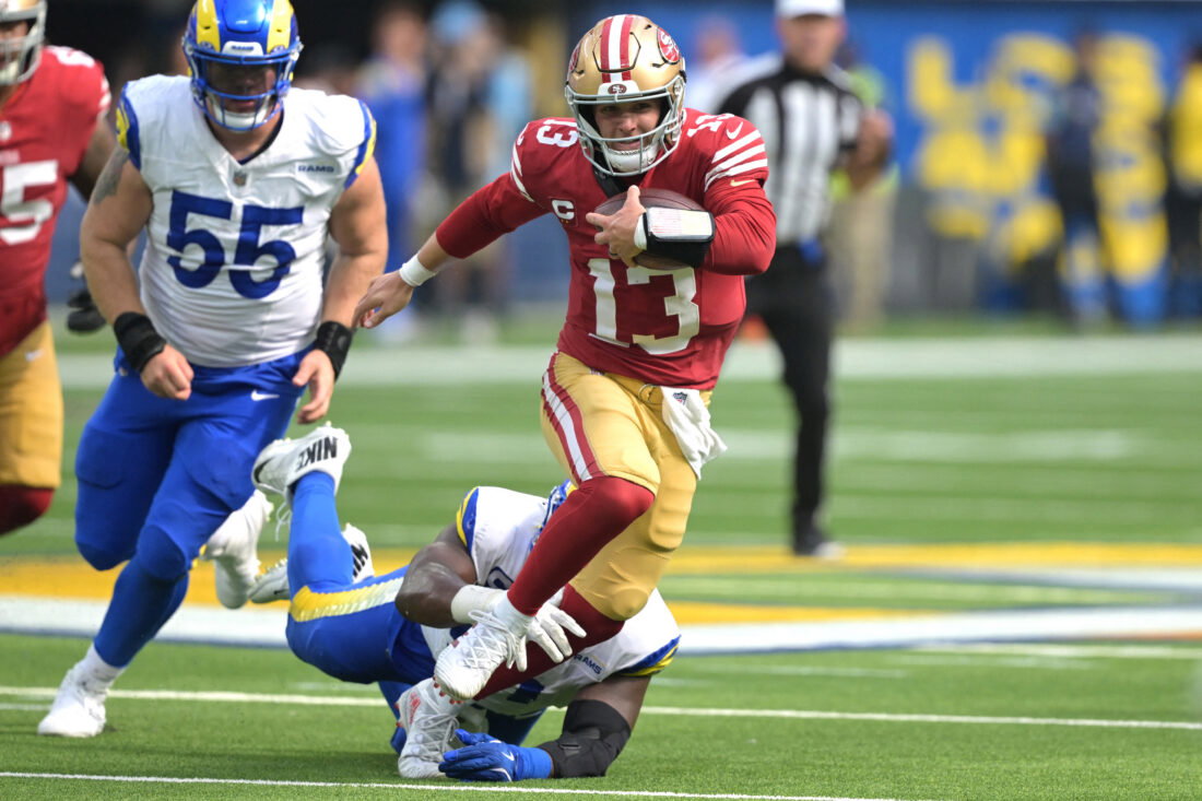 Sep 22, 2024; Inglewood, California, USA; San Francisco 49ers quarterback Brock Purdy (13) breaks away from Los Angeles Rams defensive tackle Kobie Turner (91) for a first down in the second half at SoFi Stadium. Mandatory Credit: Jayne Kamin-Oncea-Imagn Images