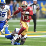 Sep 22, 2024; Inglewood, California, USA; San Francisco 49ers quarterback Brock Purdy (13) breaks away from Los Angeles Rams defensive tackle Kobie Turner (91) for a first down in the second half at SoFi Stadium. Mandatory Credit: Jayne Kamin-Oncea-Imagn Images