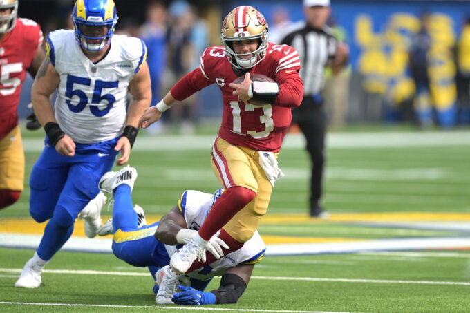 Sep 22, 2024; Inglewood, California, USA; San Francisco 49ers quarterback Brock Purdy (13) breaks away from Los Angeles Rams defensive tackle Kobie Turner (91) for a first down in the second half at SoFi Stadium. Mandatory Credit: Jayne Kamin-Oncea-Imagn Images