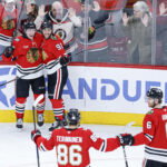 Nov 18, 2025; Chicago, Illinois, USA; Chicago Blackhawks center Oliver Moore (11) celebrates with teammates after scoring against the Calgary Flames during the third period at United Center. Mandatory Credit: Kamil Krzaczynski-Imagn Images