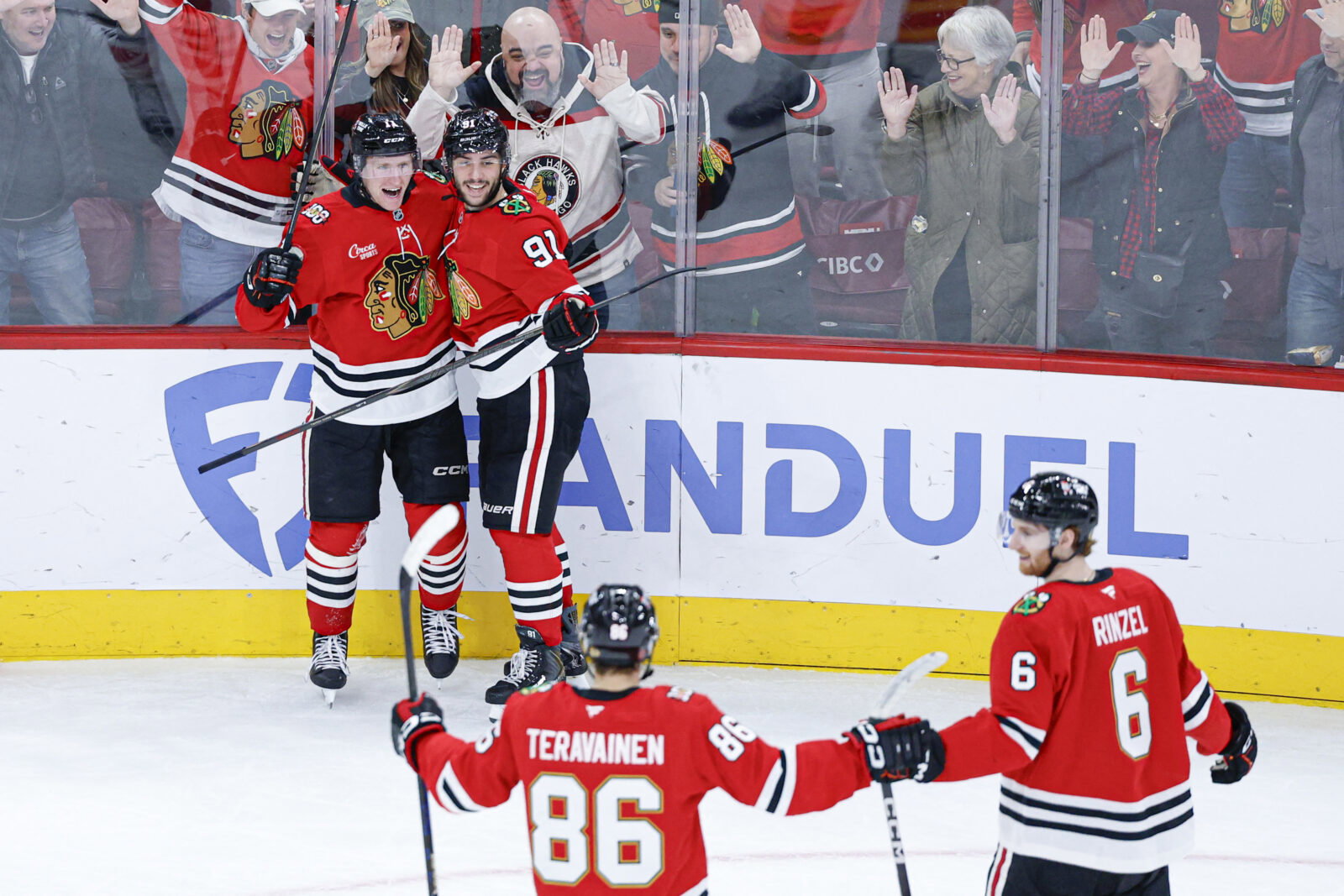 Nov 18, 2025; Chicago, Illinois, USA; Chicago Blackhawks center Oliver Moore (11) celebrates with teammates after scoring against the Calgary Flames during the third period at United Center. Mandatory Credit: Kamil Krzaczynski-Imagn Images