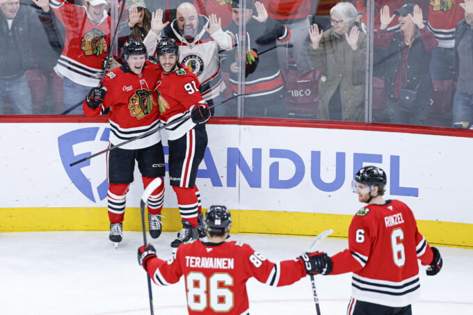 Nov 18, 2025; Chicago, Illinois, USA; Chicago Blackhawks center Oliver Moore (11) celebrates with teammates after scoring against the Calgary Flames during the third period at United Center. Mandatory Credit: Kamil Krzaczynski-Imagn Images