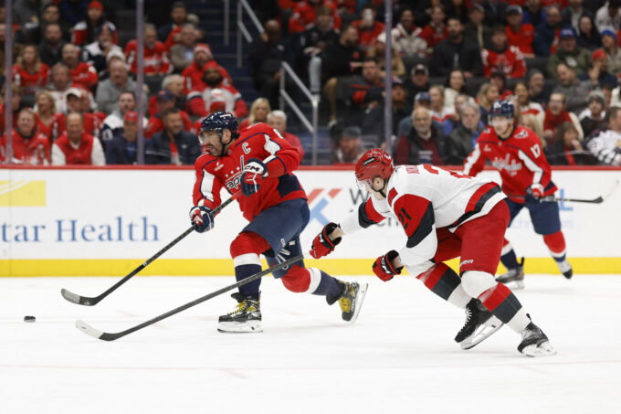 Dec 11, 2025; Washington, District of Columbia, USA; Washington Capitals left wing Alex Ovechkin (8) shoots the puck as Carolina Hurricanes defenseman Alexander Nikishin (21) defends during the third period at Capital One Arena. Mandatory Credit: Geoff Burke-Imagn Images
