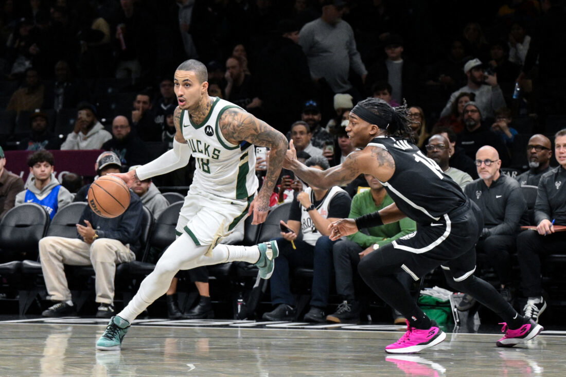 Dec 14, 2025; Brooklyn, New York, USA; Milwaukee Bucks forward Kyle Kuzma (18) drives past Brooklyn Nets guard Terance Mann (14) during the first half at Barclays Center. Mandatory Credit: John Jones-Imagn Images