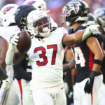 Dec 21, 2025; Glendale, Arizona, USA; Arizona Cardinals running back Corey Kiner (37) celebrates after a carry against the Atlanta Falcons during the first half at State Farm Stadium. Mandatory Credit: