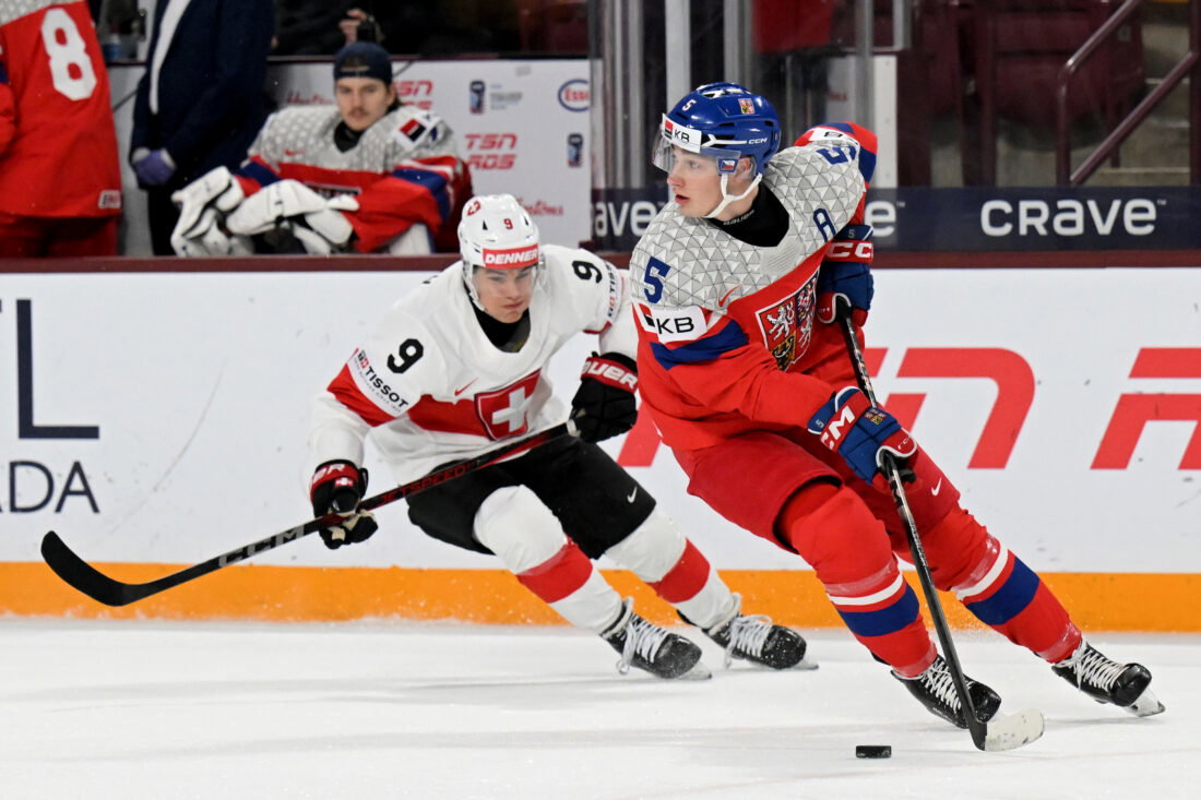 Jan 2, 2026; Minneapolis, Minnesota, USA; Czechia defensemen Adam Jiricek (5) controls the puck as Switzerland forward Nolan Cattin (9) gives chase during the first period in the quarterfinals of the 2026 IIHF World Junior Championship at 3M Arena. Mandatory Credit: Nick Wosika-Imagn Images