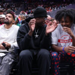 Sep 24, 2026; Washington, District of Columbia, USA; (L-R) Washington Wizards players Trae Young, AJ Dybantsa, and Bub Carrington sit courtside at the game between the Washington Mystics and Chicago Sky at Capital One Arena. Mandatory Credit: Geoff Burke-Imagn Images
