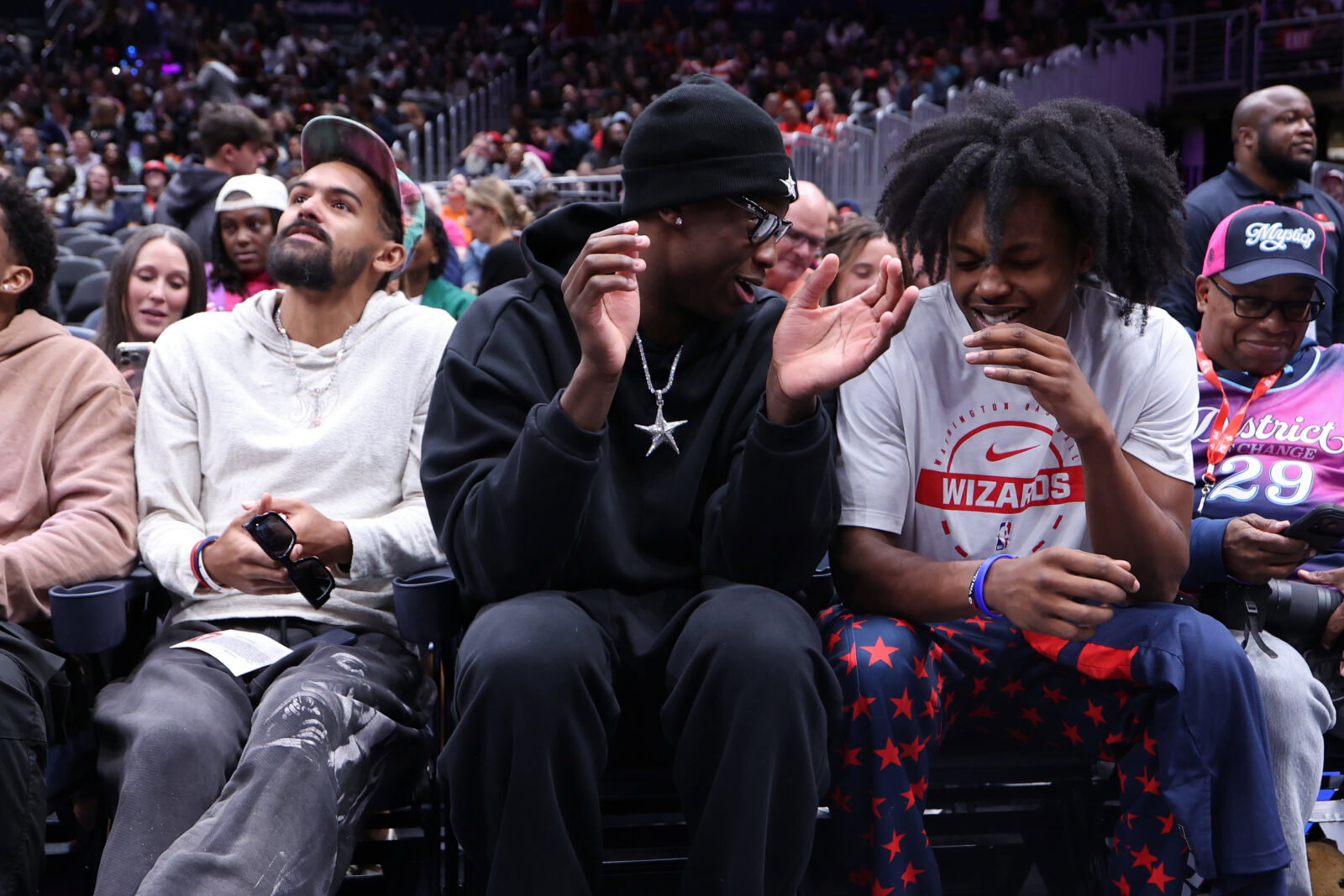Sep 24, 2026; Washington, District of Columbia, USA; (L-R) Washington Wizards players Trae Young, AJ Dybantsa, and Bub Carrington sit courtside at the game between the Washington Mystics and Chicago Sky at Capital One Arena. Mandatory Credit: Geoff Burke-Imagn Images