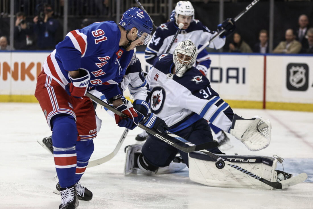 Nov 12, 2024; New York, New York, USA; Winnipeg Jets goaltender Connor Hellebuyck (37) defends against a shot on goal attempt by New York Rangers right wing Reilly Smith (91) in the second period at Madison Square Garden. Mandatory Credit: Wendell Cruz-Imagn Images