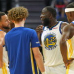 Dec 25, 2025; San Francisco, California, USA; Golden State Warriors forward Draymond Green (23) talks with guard Stephen Curry (30) with guard Brandin Podziemski (center left) and forward Jimmy Butler III (10) during the third quarter against the Dallas Mavericks at Chase Center. Mandatory Credit: Darren Yamashita-Imagn Images