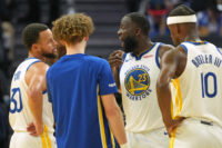 Dec 25, 2025; San Francisco, California, USA; Golden State Warriors forward Draymond Green (23) talks with guard Stephen Curry (30) with guard Brandin Podziemski (center left) and forward Jimmy Butler III (10) during the third quarter against the Dallas Mavericks at Chase Center. Mandatory Credit: Darren Yamashita-Imagn Images