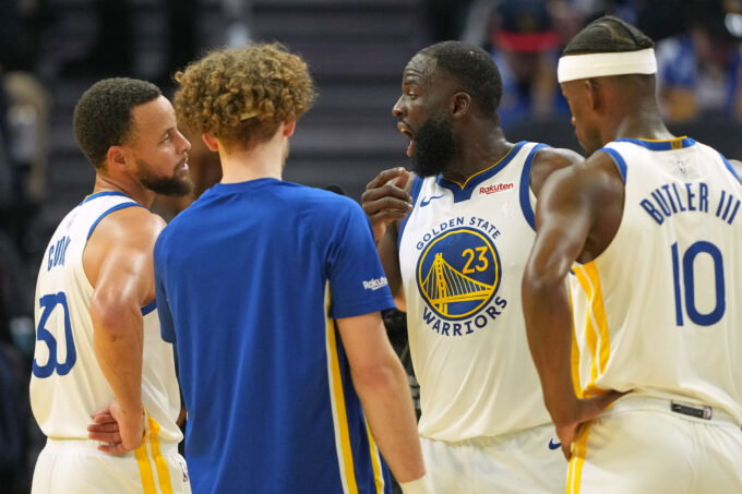 Dec 25, 2025; San Francisco, California, USA; Golden State Warriors forward Draymond Green (23) talks with guard Stephen Curry (30) with guard Brandin Podziemski (center left) and forward Jimmy Butler III (10) during the third quarter against the Dallas Mavericks at Chase Center. Mandatory Credit: Darren Yamashita-Imagn Images