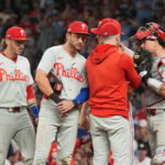 Oct 1, 2026; Cumberland, Georgia, USA; Philadelphia Phillies infielder Trea Turner (7) listens to pitching coach Caleb Cotham (65) with infielders Bryson Stott (5) and Edmundo Sosa (33) during a mound visit against the Atlanta Braves in the sixth inning in game three of the Wildcard round for the 2026 MLB Playoffs at Truist Field. Mandatory Credit: Dale Zanine-Imagn Images