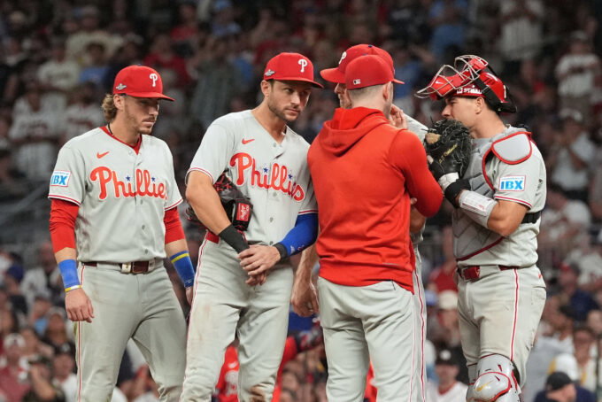 Oct 1, 2026; Cumberland, Georgia, USA; Philadelphia Phillies infielder Trea Turner (7) listens to pitching coach Caleb Cotham (65) with infielders Bryson Stott (5) and Edmundo Sosa (33) during a mound visit against the Atlanta Braves in the sixth inning in game three of the Wildcard round for the 2026 MLB Playoffs at Truist Field. Mandatory Credit: Dale Zanine-Imagn Images