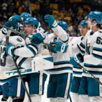 Oct 15, 2026; Nashville, Tennessee, USA; San Jose Sharks goaltender Alex Nedeljkovic (33) celebrates with his teammates after the shootout win Nashville Predators during the overtime period at Bridgestone Arena. Mandatory Credit: Steve Roberts-Imagn Images