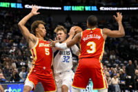 Oct 16, 2026; Dallas, Texas, USA; Dallas Mavericks forward Cooper Flagg (32) drives to the basket between Atlanta Hawks guard Dyson Daniels (5) and guard CJ McCollum (3) during the first quarter at American Airlines Center. Mandatory Credit: Jerome Miron-Imagn Images