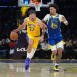 Oct 21, 2026; Los Angeles, California, USA; Los Angeles Lakers guard Luka Doncic (77) drives to the basket against Golden State Warriors forward Yaxel Lendeborg (1) in the first half at Crypto.com Arena. Mandatory Credit: Kirby Lee-Imagn Images