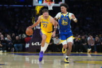Oct 21, 2026; Los Angeles, California, USA; Los Angeles Lakers guard Luka Doncic (77) drives to the basket against Golden State Warriors forward Yaxel Lendeborg (1) in the first half at Crypto.com Arena. Mandatory Credit: Kirby Lee-Imagn Images